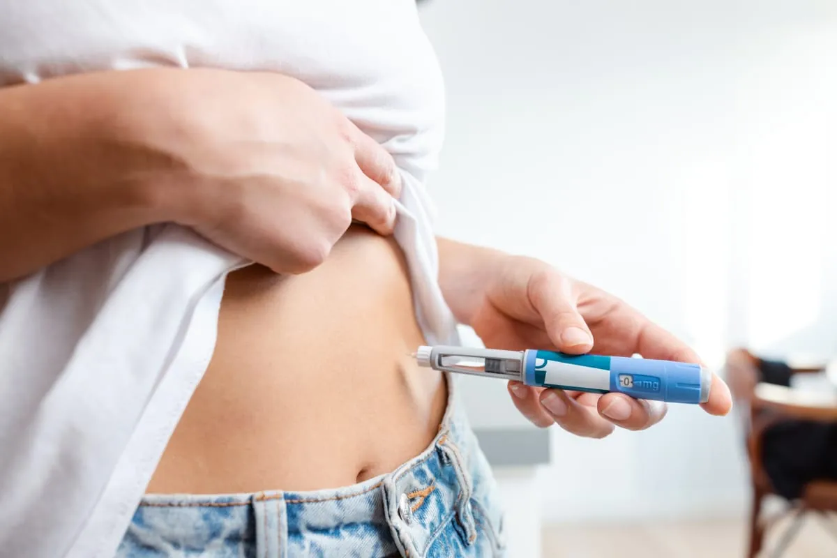 Patient using a weekly tirzepatide injection pen for weight loss